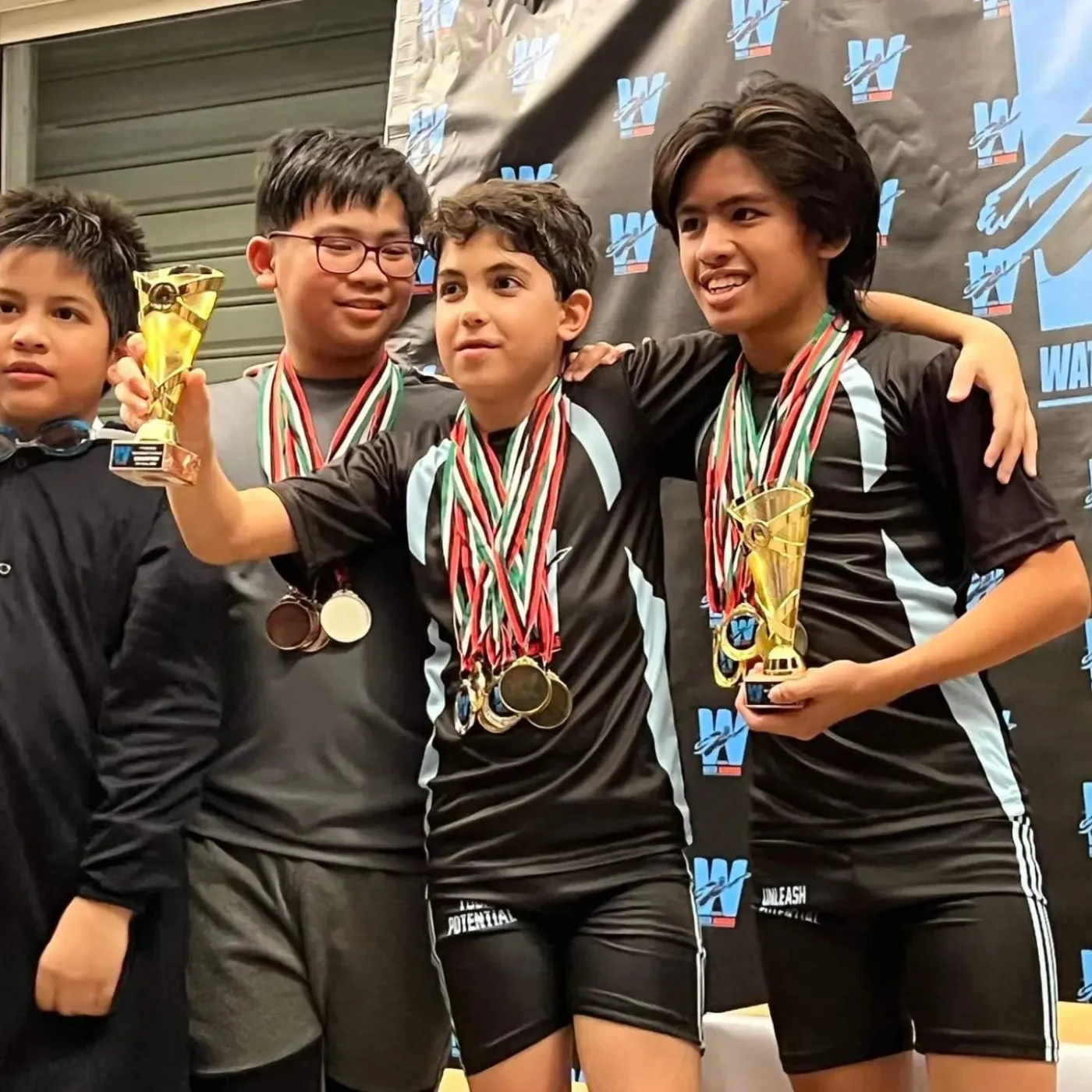 Water Warriors teammates sharing a proud moment with their trophies and medals